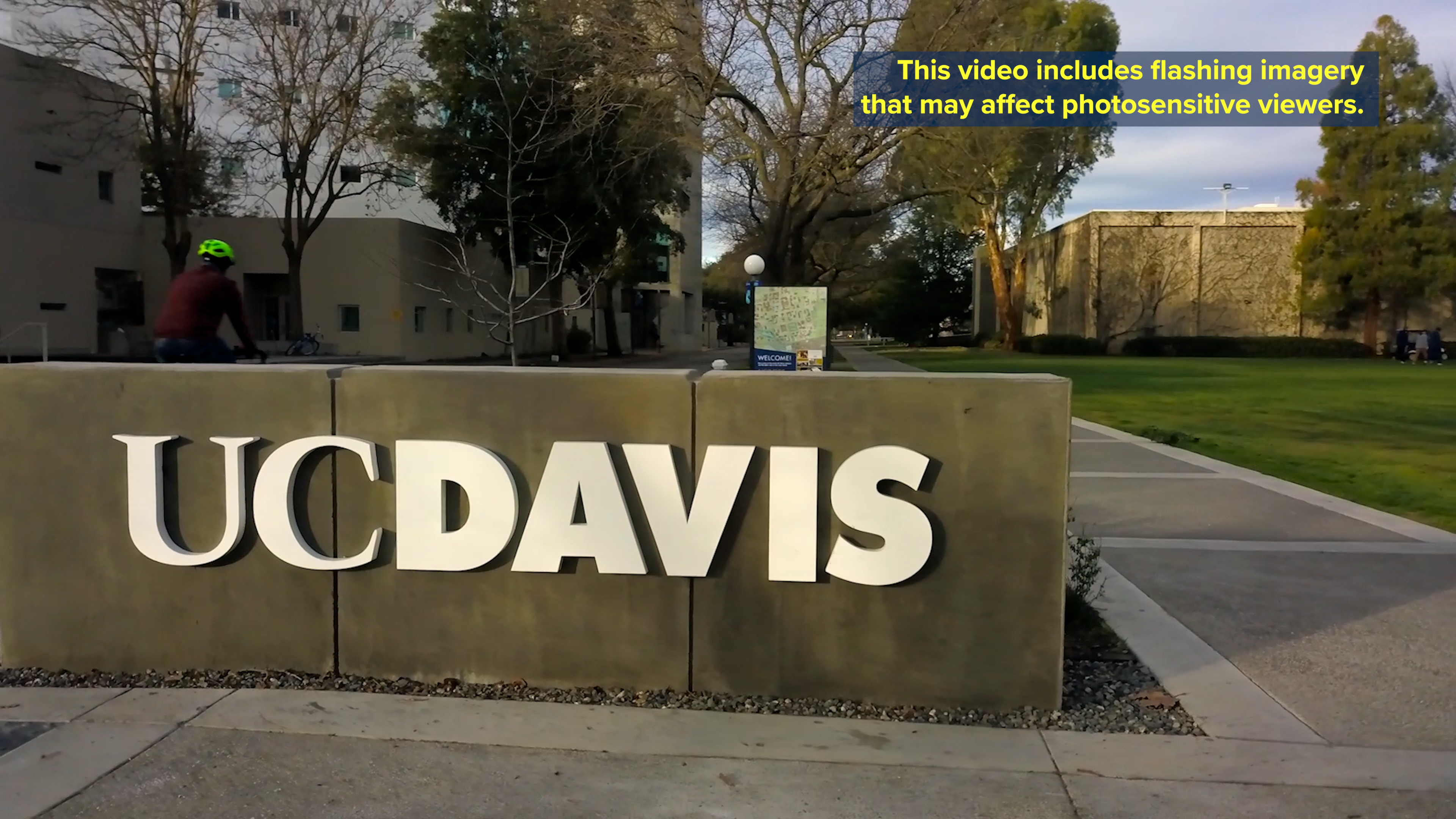 concrete UC Davis sign with white letters and disclaimer notice text