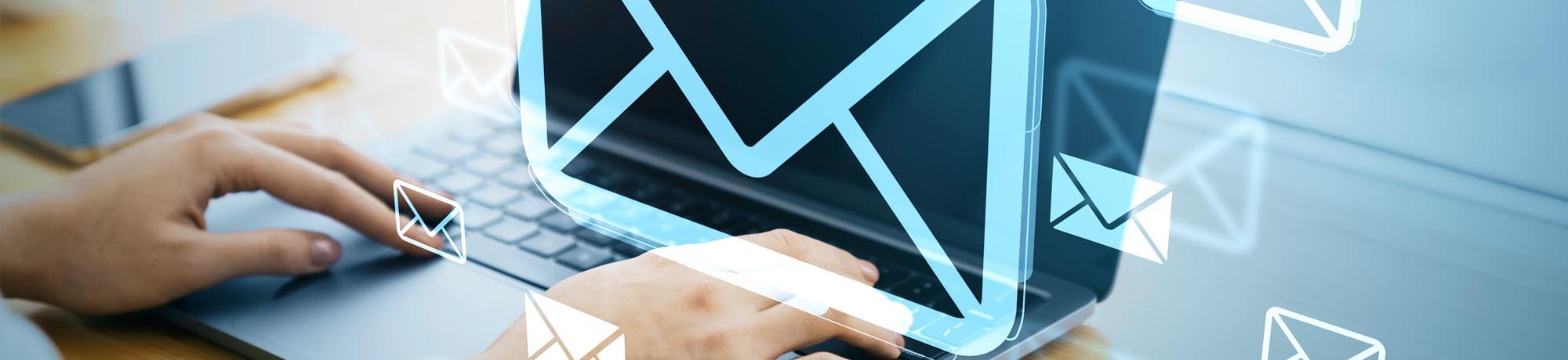 A person typing on their laptop with envelope icons illustrated over the scene
