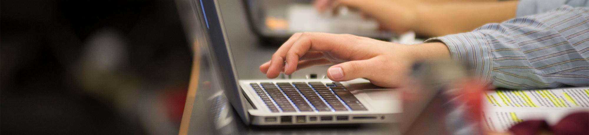 Hand typing on a laptop's keyboard